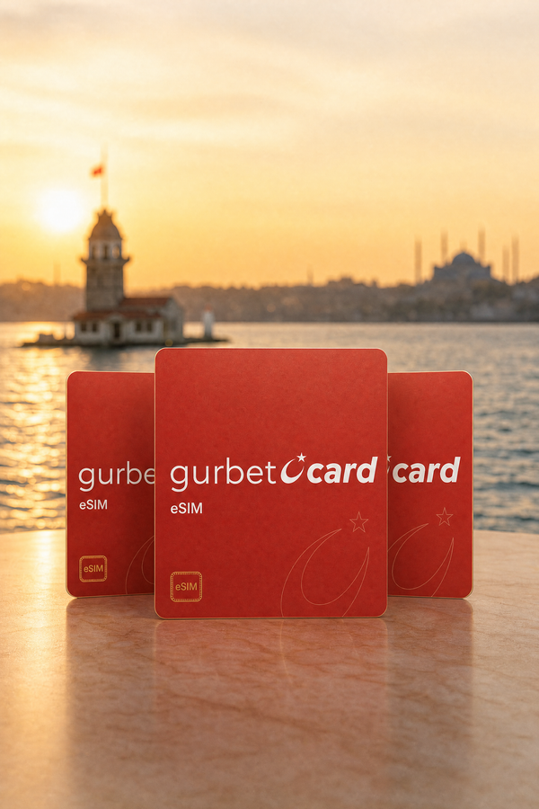 Drei rote GurbetciCard-Karten stehen vor dem Mädchenturm im Sonnenuntergang.